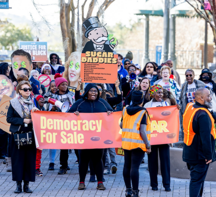 A group of people holding signs and walking down the street.