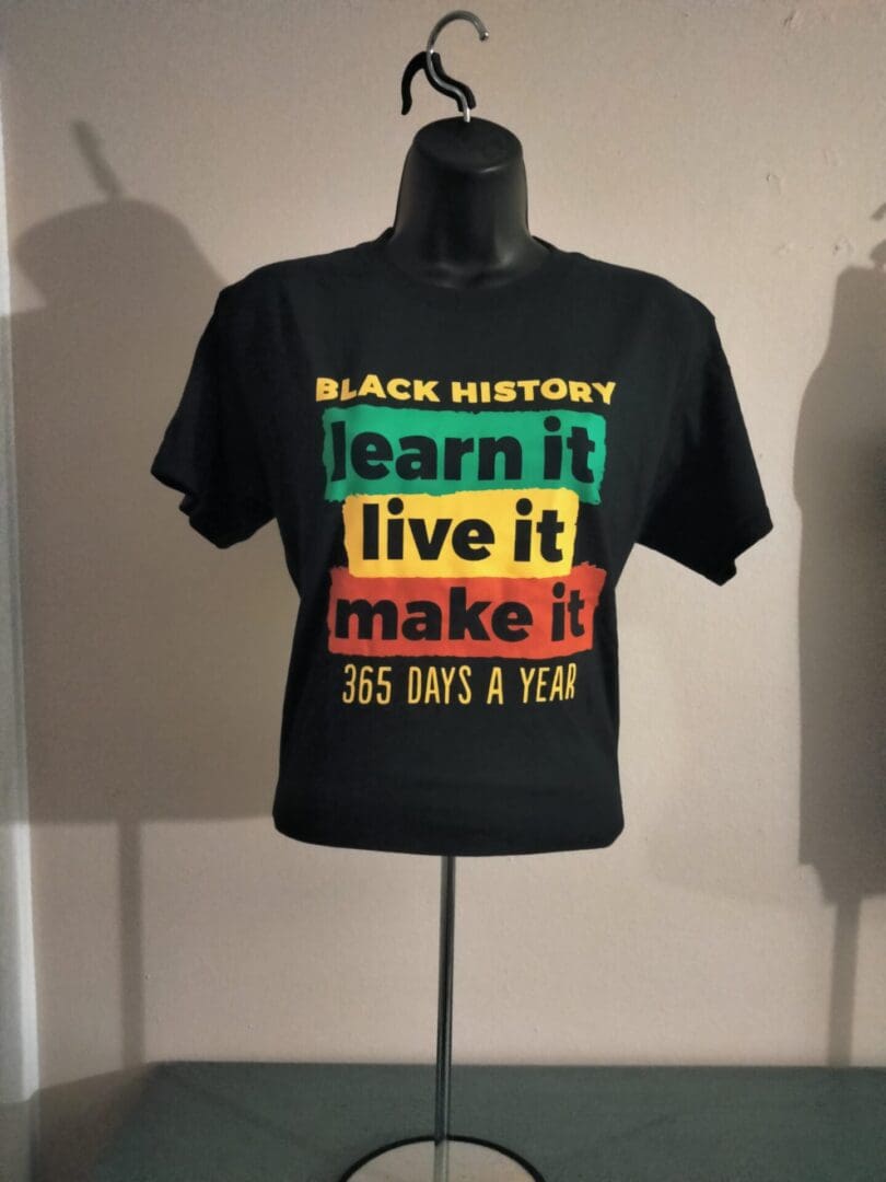 A black shirt with the words " black history learn it live it make it this goes a year ".